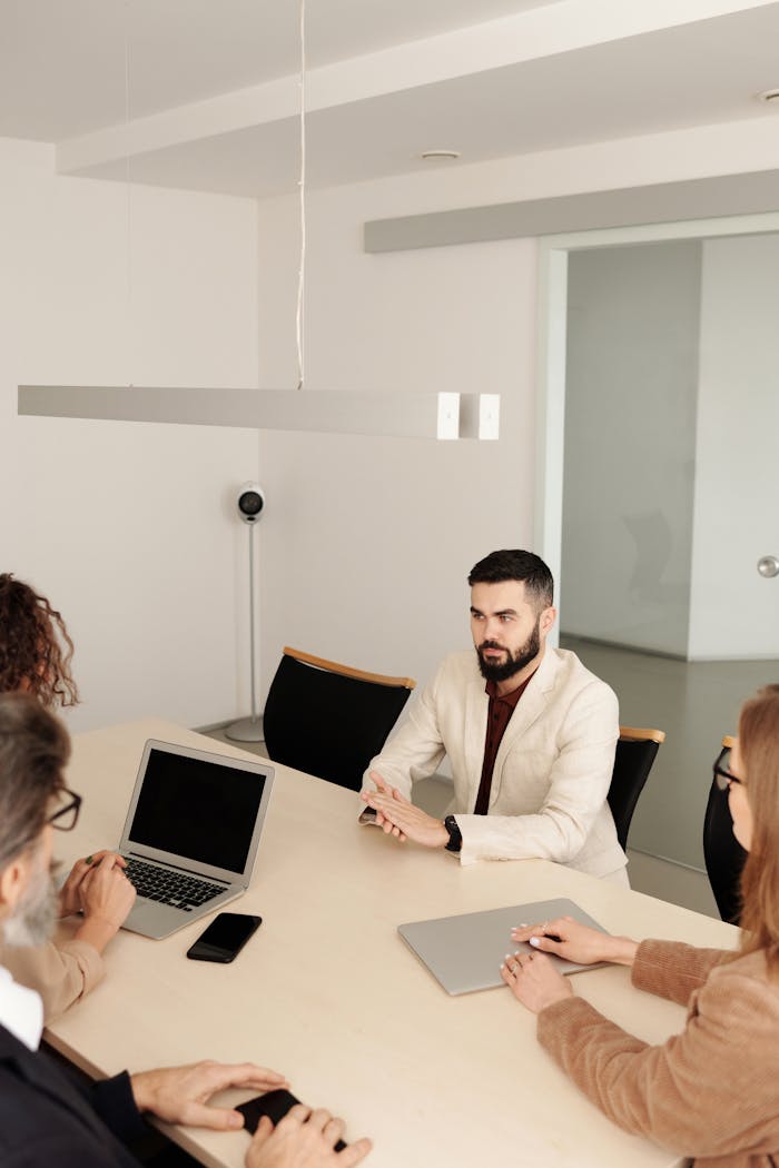 A diverse group engaged in a business meeting in a modern office setting.