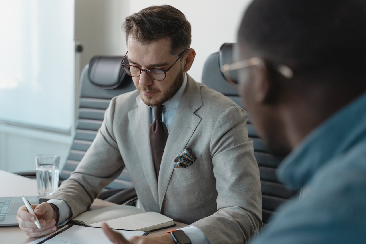 Two professionals having a focused discussion during a business meeting in an office setting.